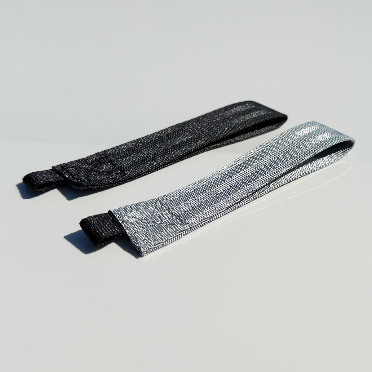 Gray and black STRIX woven racing lanyard keychains.